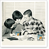 Three people are sitting at a table, reviewing documents together. On the table, there are two cans with the letter 'H'.