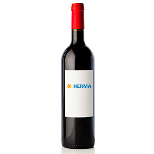 A bottle of red wine with a red cork and a white label that has the word 'HERMA' written in blue.
