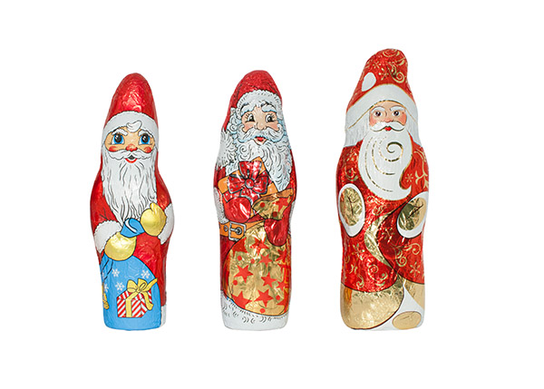 Three decorative chocolate Santas, each in different designs and colors, stand side by side.