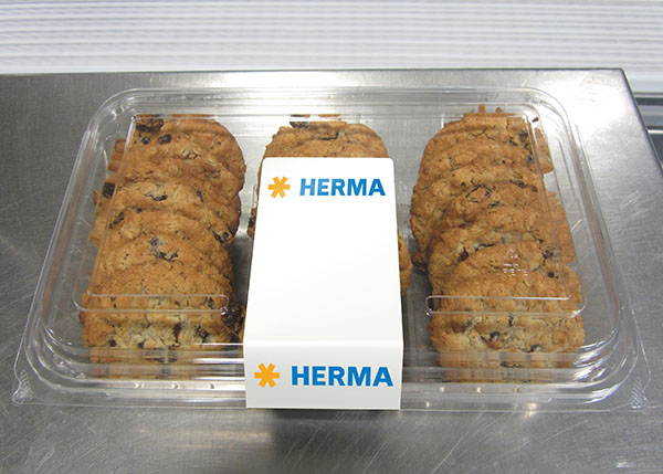 A package containing several chocolate cookies, separated in the middle by a label that reads 'HERMA.