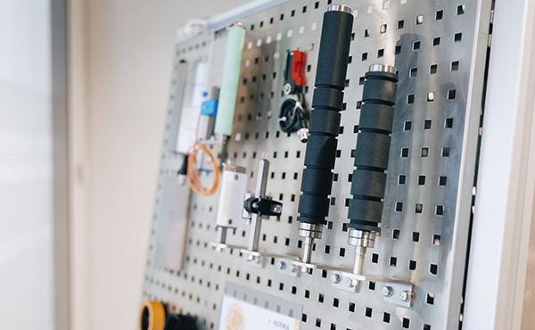 Tool panel with various handles, switches, and accessories attached to a metal plate.
