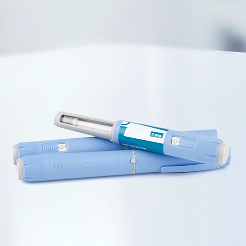 Two blue insulin pens are lying on a smooth surface, one with a removable cap and a window to display the dosage.