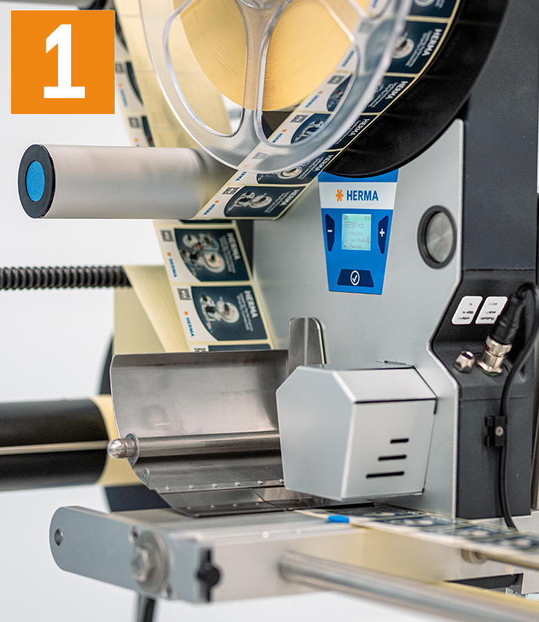 Labeling machine with a roll of labels, control display, and operating controls. The machine is ready for the labeling process.