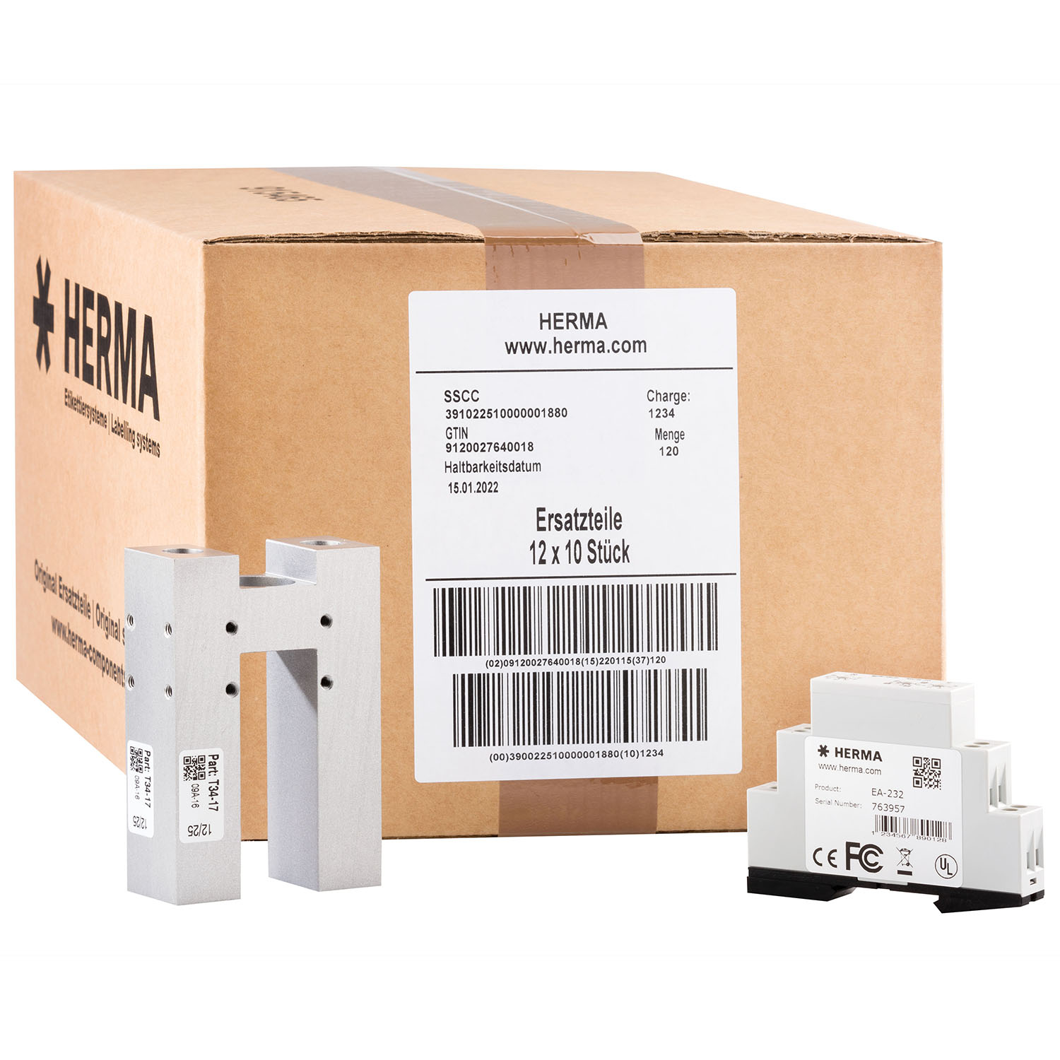 Box with spare parts from HERMA, including two aluminum pieces and several smaller components.