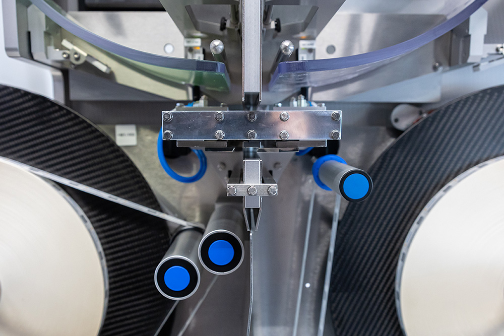 Machine with multiple pipes and blue handles, designed for processing materials or products.