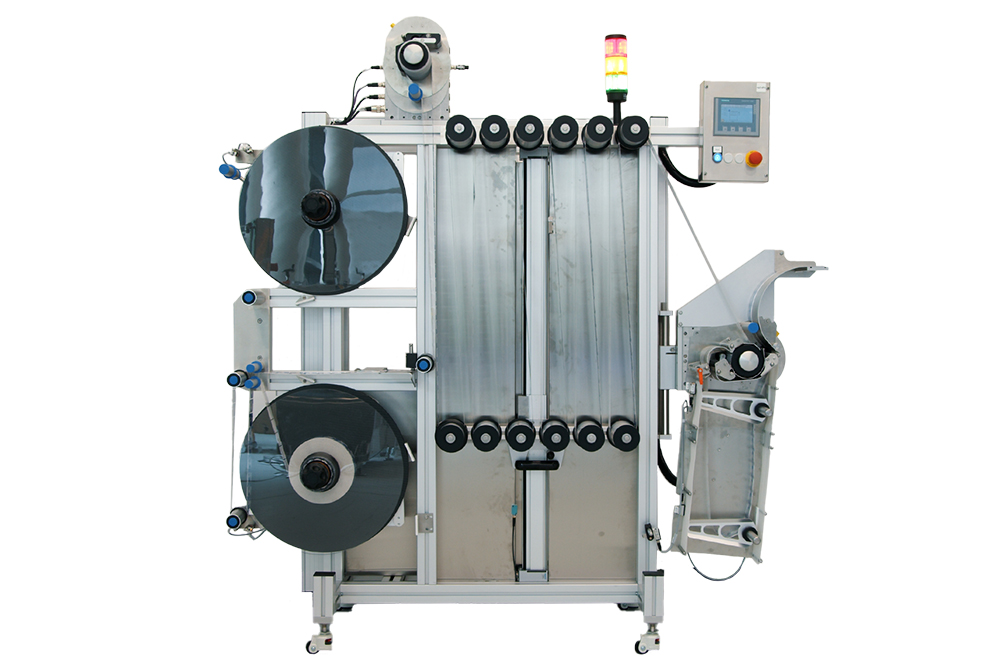 Machine for processing films with two large spools, control unit, and output chute on the right side.