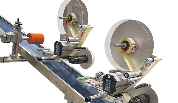 A conveyor system with two rollers that applies labels to products. The machine is equipped with motors and control elements.