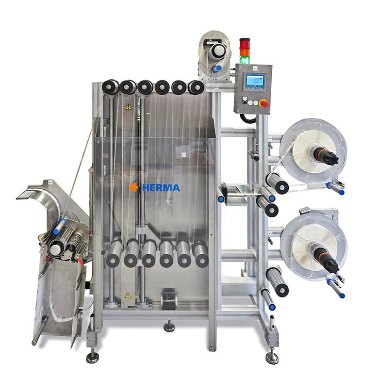 Automatic labeling machine with multiple rolls, control unit, and stainless steel frame. Ideal for industrial applications.