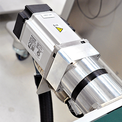 An industrial device with a metallic cylinder and an electrical connection, used for technical applications.