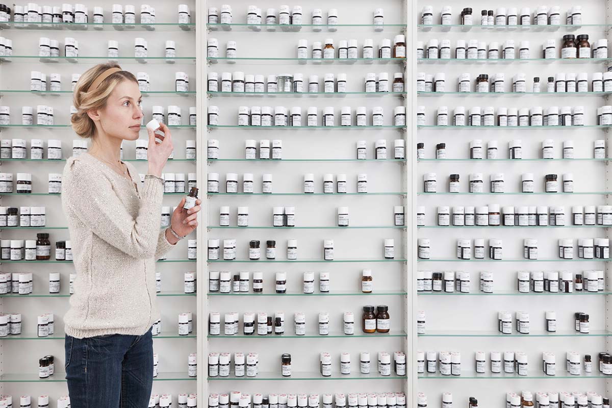 Woman in front of a shelf with artificial fragrances.