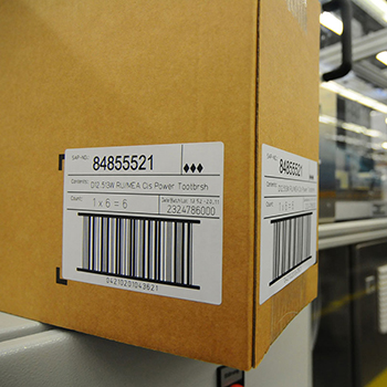 Laser-activated labels: Shipping label on brown cardboard in logistics.