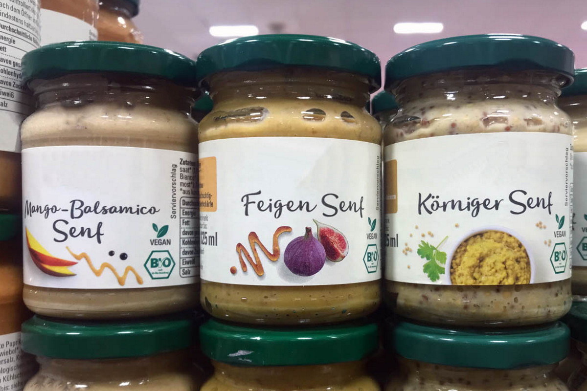 Order roll labels online in digital printing: glass labels on mustard, on the shelf.