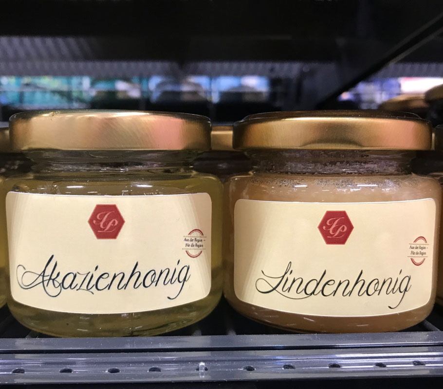 Order roll labels online in digital printing: Honey labels for acacia honey on the shelf.