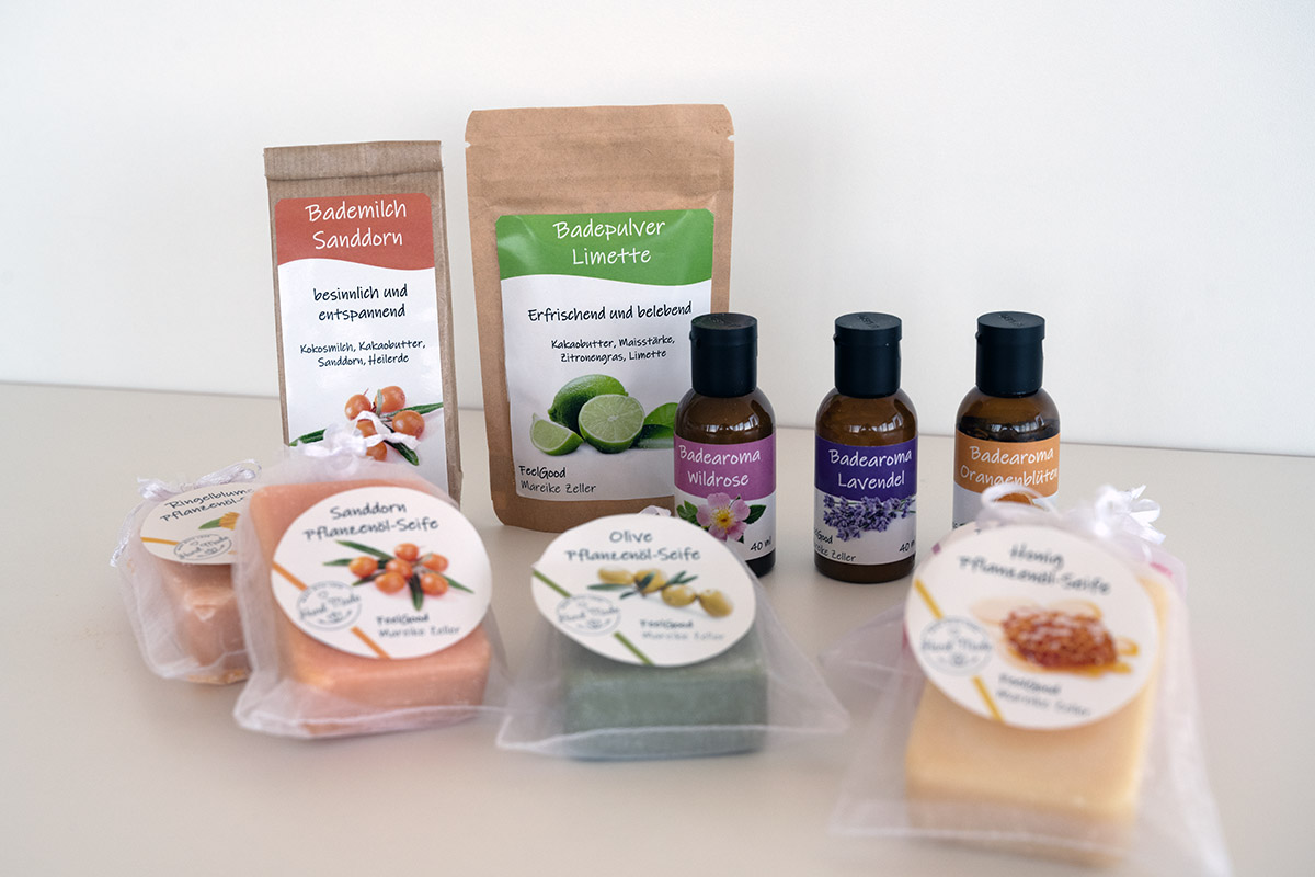 Order roll labels online in digital printing: Cosmetik products, such as bath powders, bath oils, and soaps in different colors and scents, set against a neutral background.