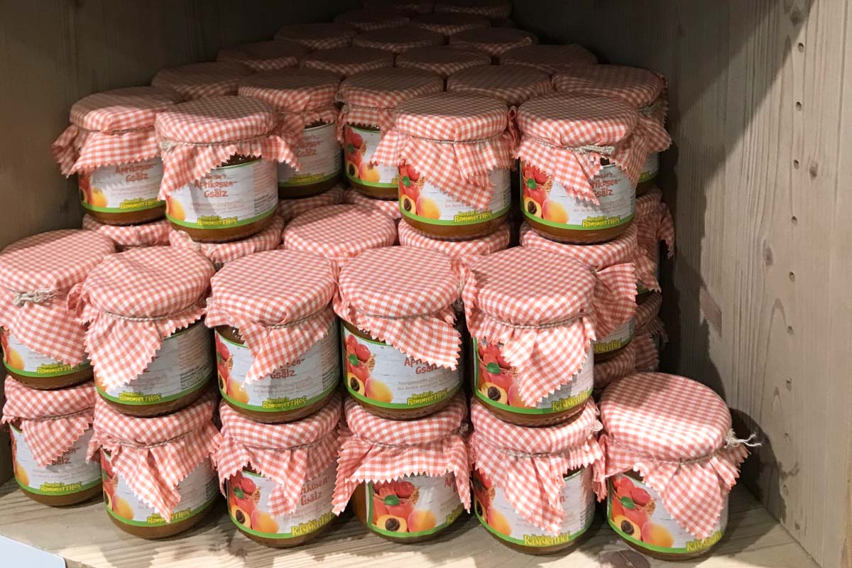 Order roll labels for digital printing online: jam labels on jars with fruit spreads, many jars on the shelf, close-up.