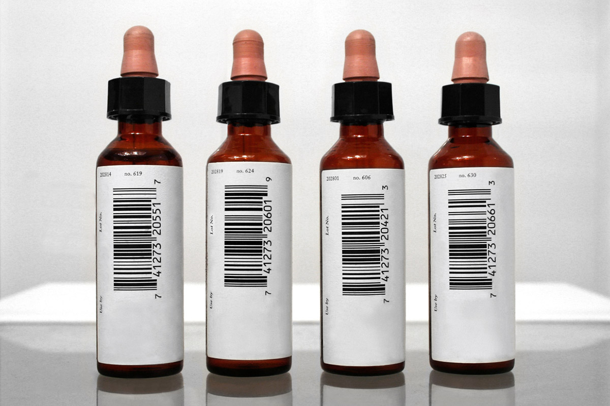 Round labeling: Barcode labels on four brown medicine bottles with pipette caps.