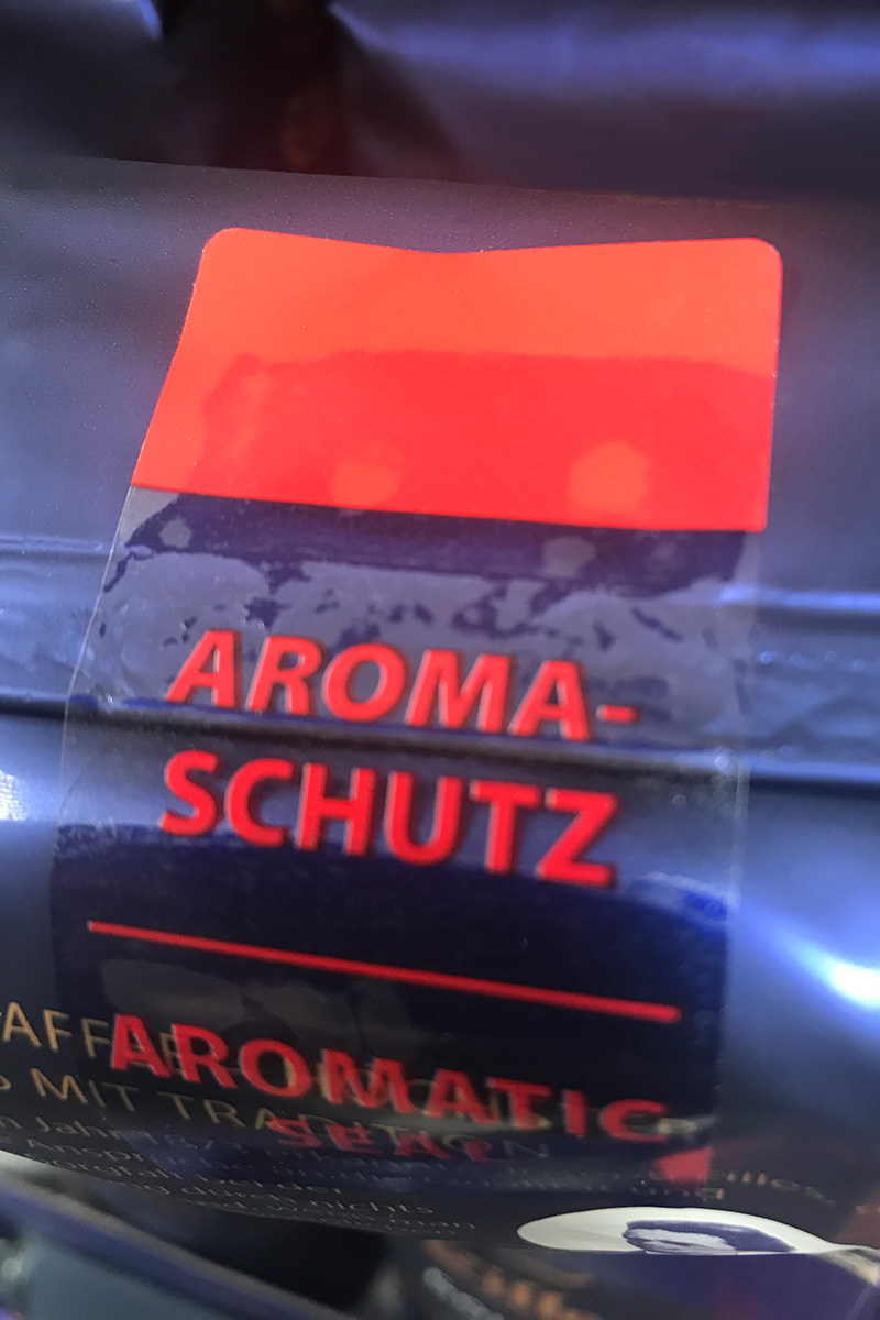 Closure labels: transparent resealable label, printed in color, on foil coffee packaging.
