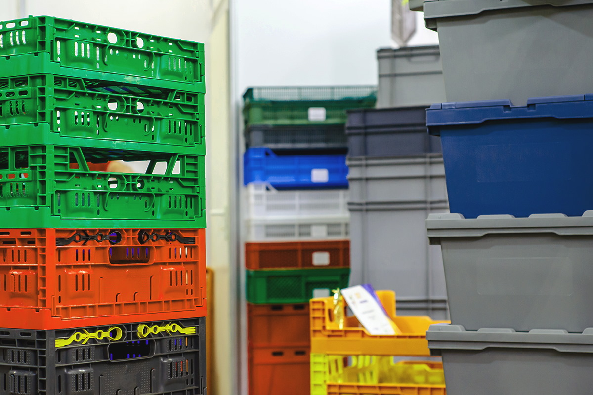 Colored stacked reusable containers, ideal for labeling with wash-off labels.