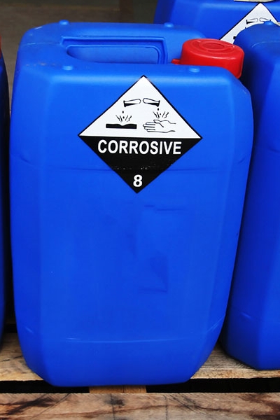 Hazardous substance and hazardous goods labels: Hazardous goods labels on blue plastic canisters in the chemical industry.