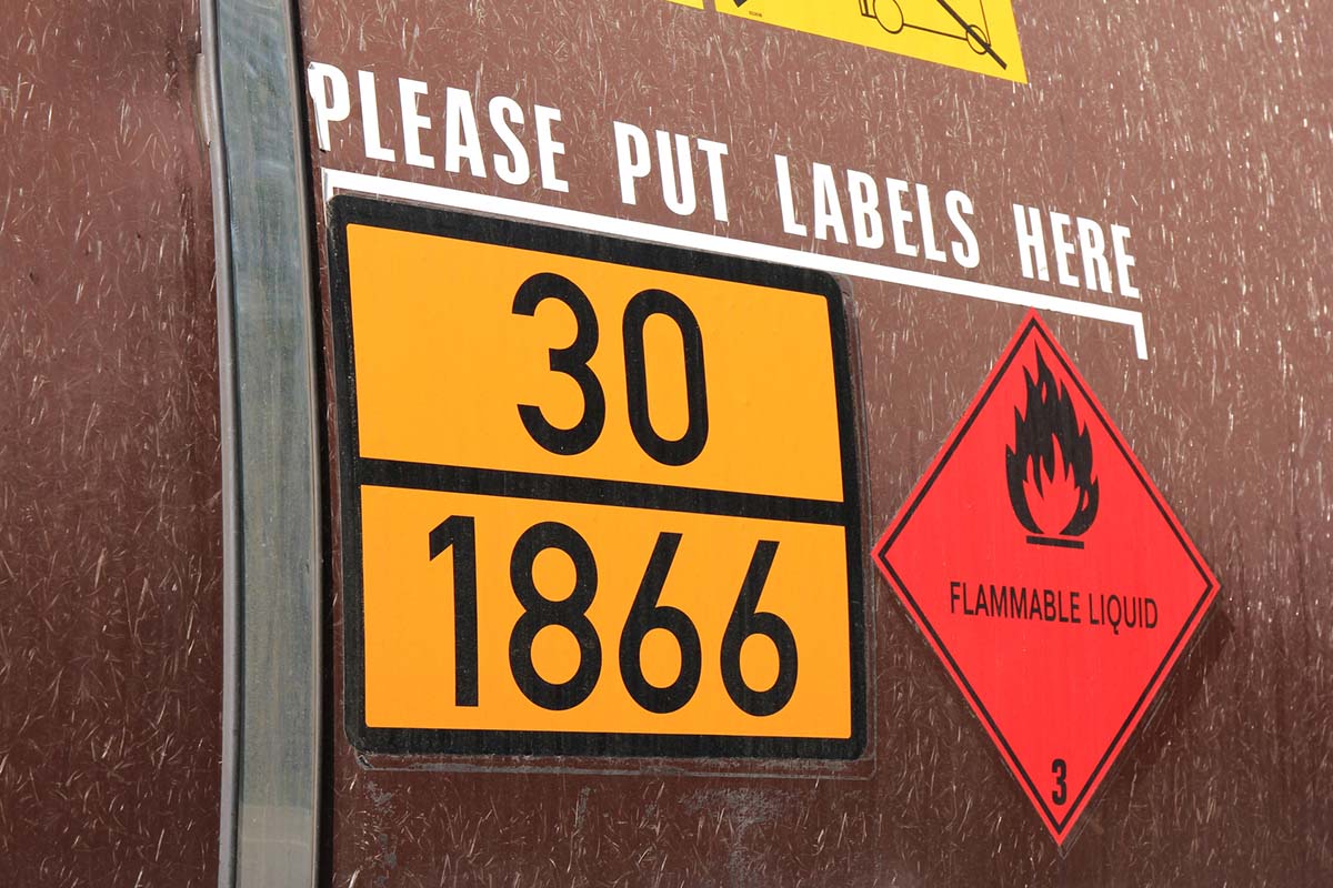 Hazardous substance and hazardous goods labels: Orange warning sign with identification numbers on brown tank trucks.