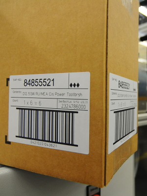 Laser-activatable labels: Shipping label on brown cardboard in logistics.