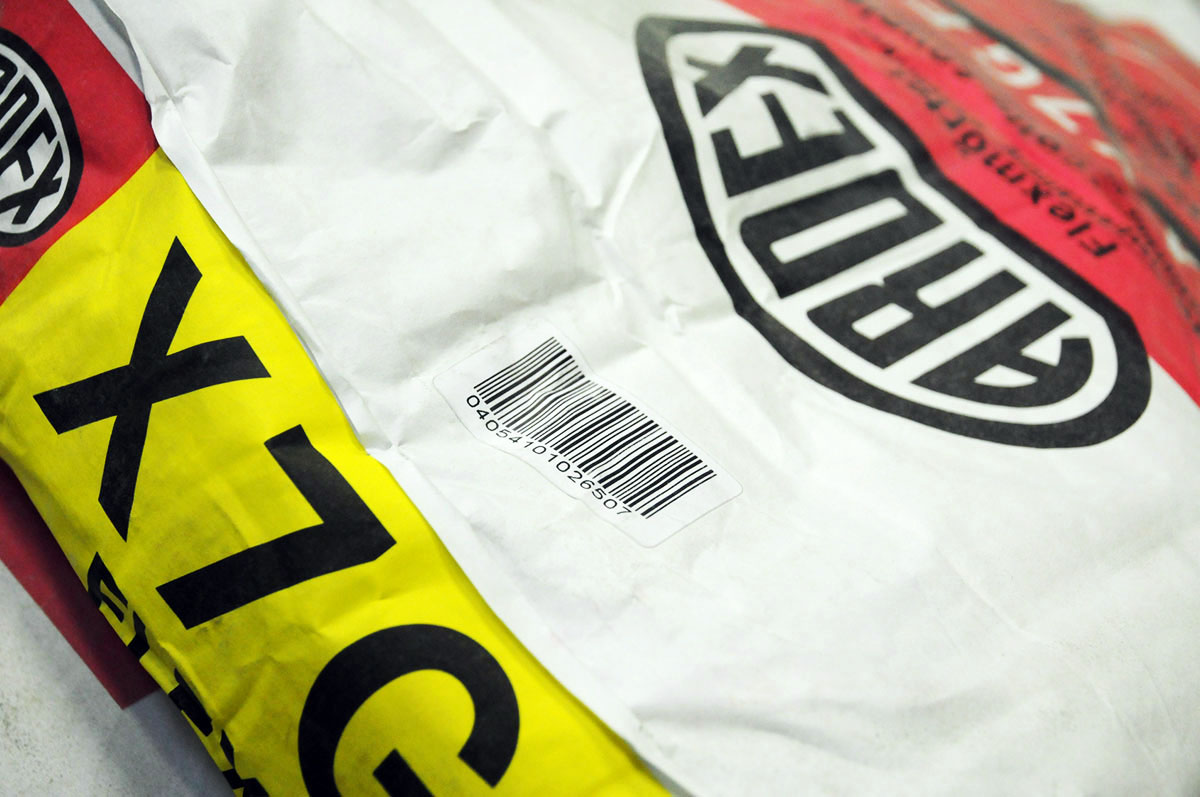 Product Labeling: Laser-activatable label with barcode, on a dusty mortar bag.