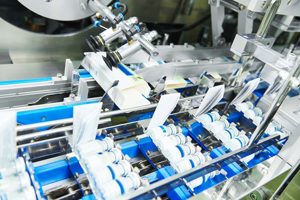 Wrap-around labelling: Labels on white glass containers in the filling line, from above