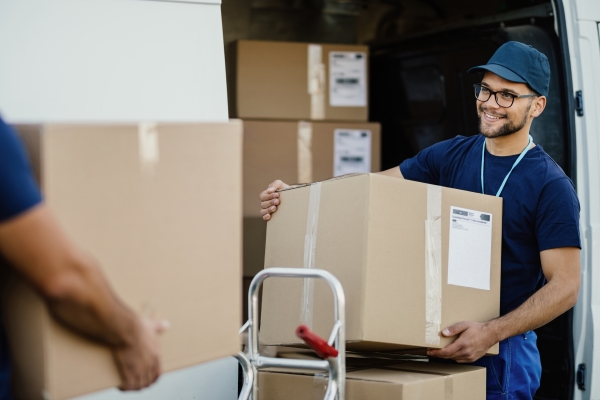 Shipping and pallet labels: Package delivery with a delivery van, freight staff places the shipping box on a pallet truck.