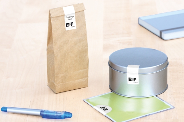 Closure Labels: White closure labels on a brown bag, a metal can, and a plastic pouch.