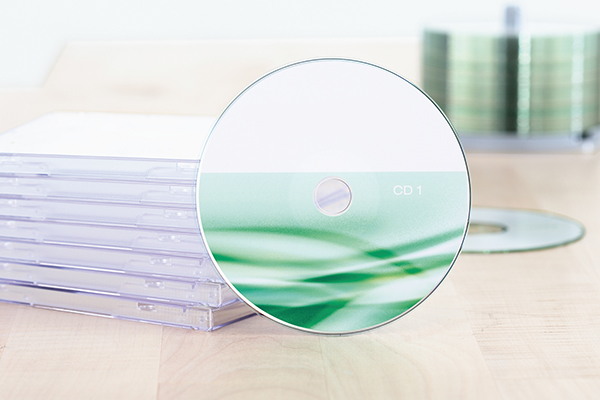 Instructions for submitting print data, CD in front of a stack of jewel cases.