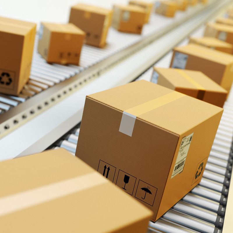 Shipping and pallet labels: Shipping label on brown boxes, on the conveyor belt in logistics, from the front.