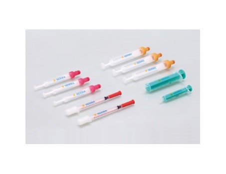 A arrangement of syringes in various colors and sizes, some with colored caps, against a neutral background.