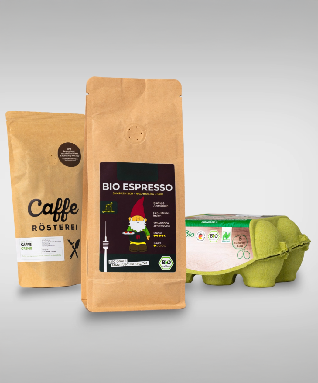 Two bags of coffee and a pack of organic eggs. One bag contains organic espresso with a colorful label.
