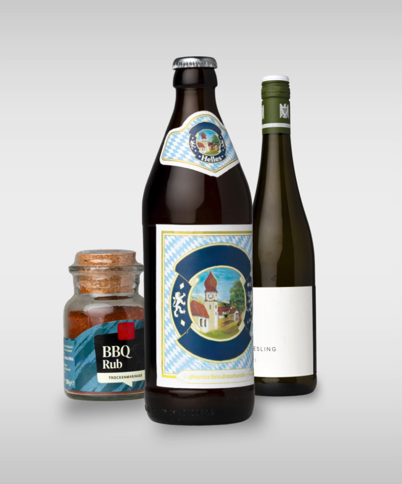 A bottle of pale lager, a bottle of Riesling, and a glass of BBQ rub are lined up side by side against a neutral background.