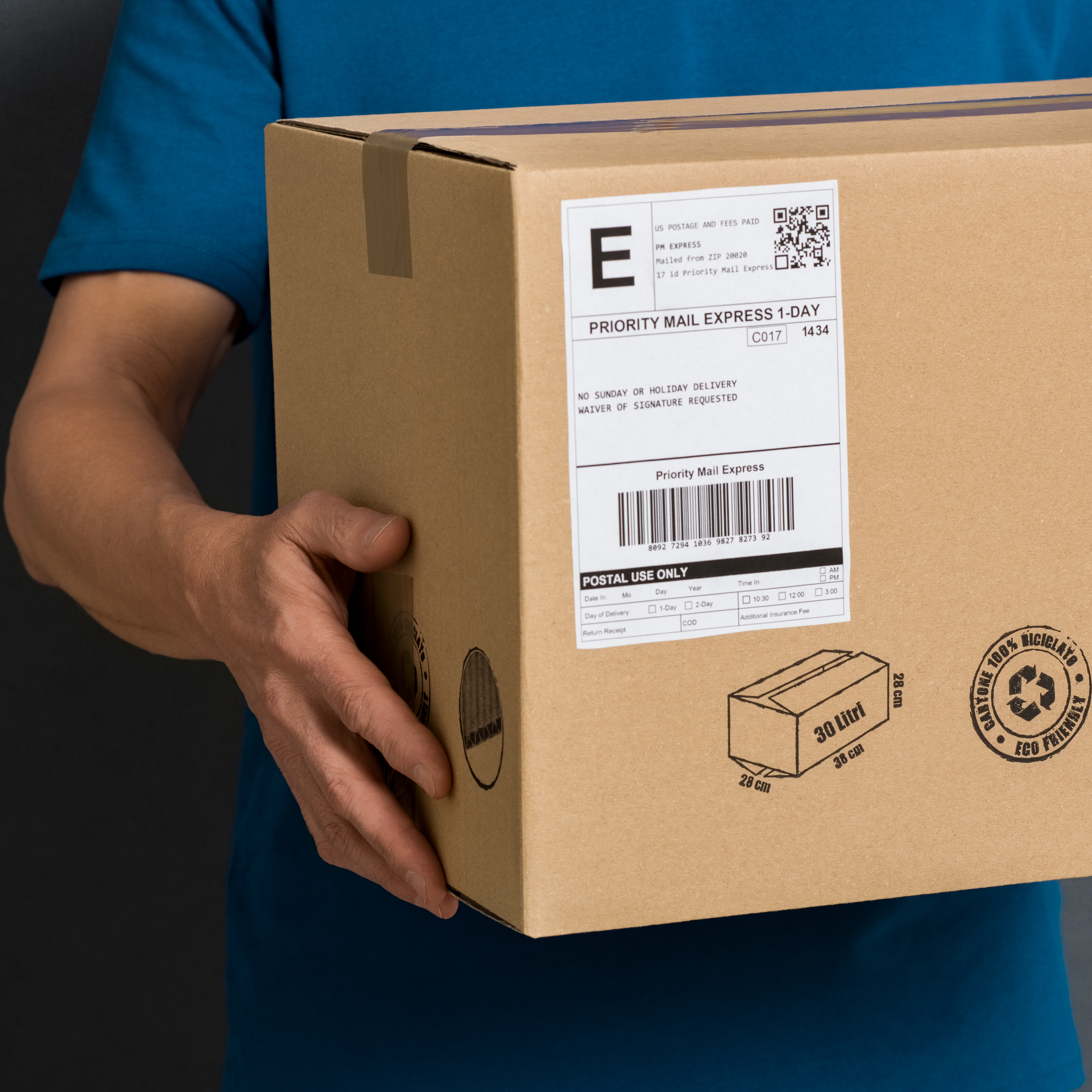 A person is holding a brown package with a shipping label that says 'Priority Mail Express.