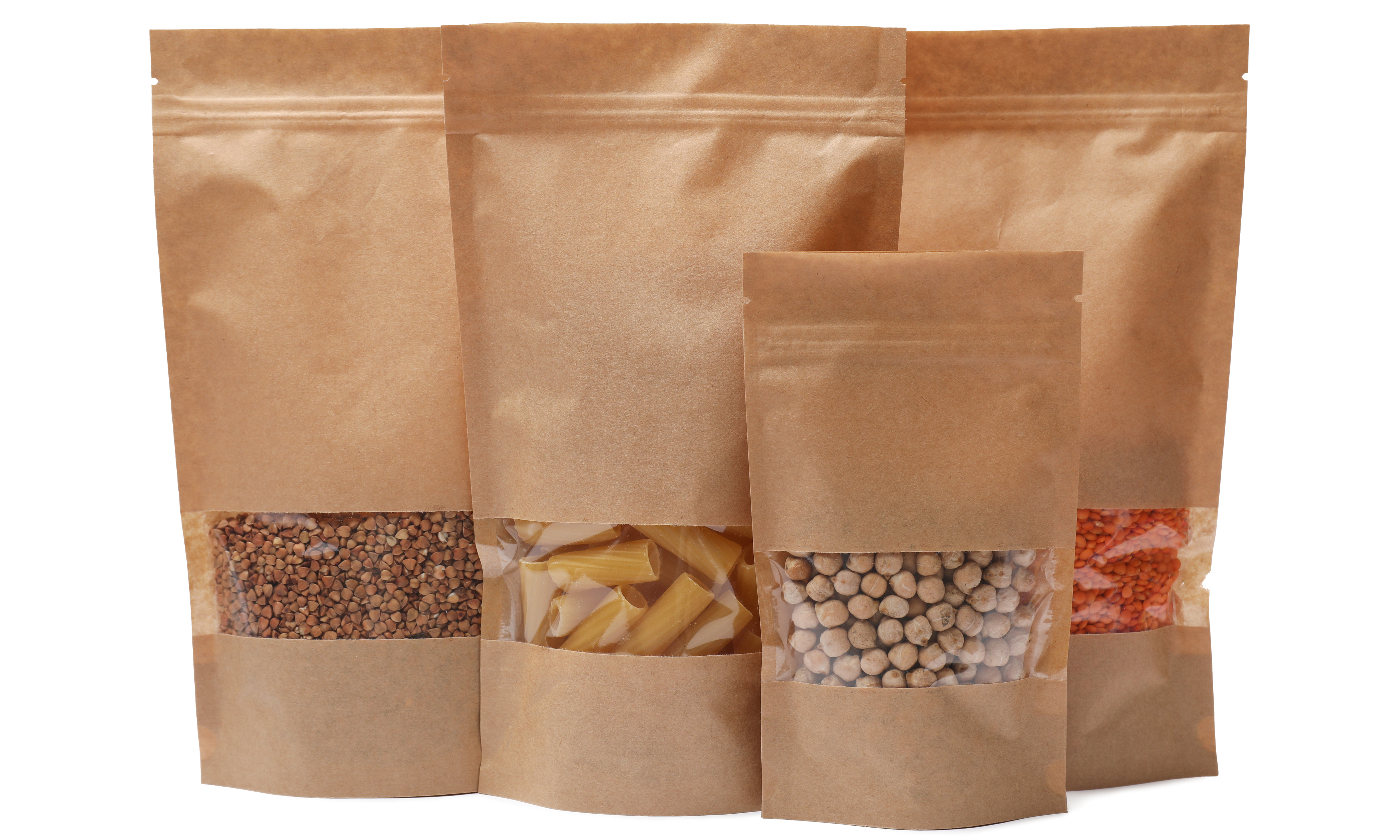 Various brown paper bags with transparent windows, filled with legumes, pasta, and other food items.