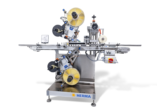 Automatic labeling machine with two labeling heads, equipped with rollers and control elements, on a sturdy frame.