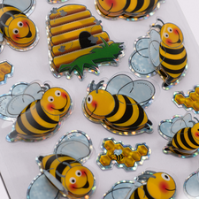 Bunte Aufkleber von Bienen und einem Bienenstock, mit verschiedenen Designs und Farben, auf einem weißen Hintergrund.