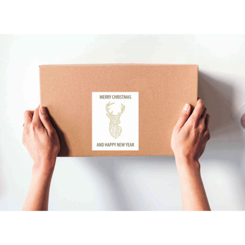 Braune Geschenkbox mit einem Aufkleber, der einen Hirsch und den Text „Frohe Weihnachten und ein glückliches neues Jahr“ zeigt.