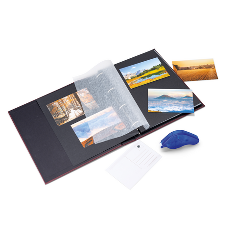An open photo album with several pictures, a transparent protective sheet, and a blue glue stick next to it.