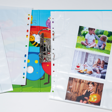 Ein farbenfrohes Album mit transparenten Hüllen und Bildern von Kindern bei verschiedenen Aktivitäten, darunter Essen und Spielen.