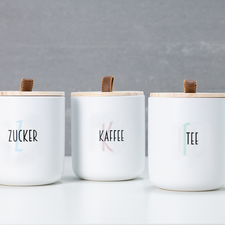 Drei Parfümflaschen, eine mit rosa Flüssigkeit und zwei mit klarer Flüssigkeit, alle mit dem Aufdruck "TESTER".