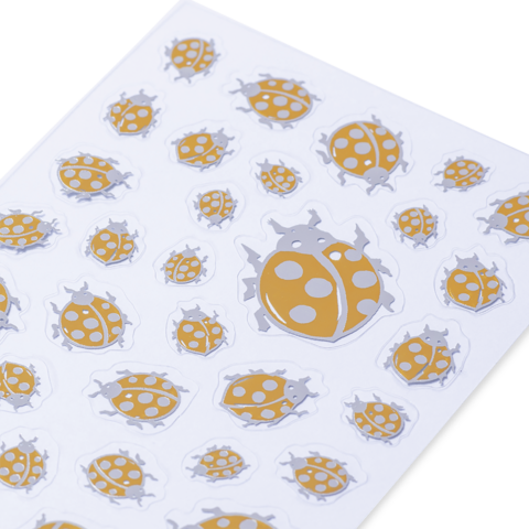 Eine Sammlung von Aufklebern mit verschiedenen Marienkäfern in Gelb und Grau auf einem weißen Hintergrund.