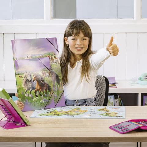 Ein Mädchen mit langen Haaren zeigt Daumen hoch, während sie ein Puzzle mit einem Pferdemotiv und eine Karte auf einem Tisch präsentiert.