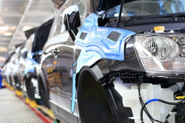 Body manufacturing on the assembly line in the automotive industry, landscape format.