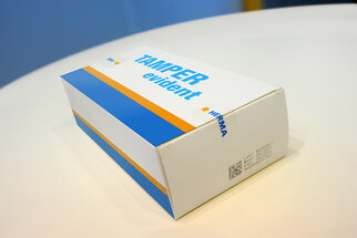Packaging labeled 'TAMPER evident' in blue and orange, produced by HERMA.