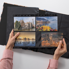 Eine Person hält ein Fotoalbum mit vier Bildern, darunter Landschaften und Stadtansichten, während der Hintergrund schwarz ist.