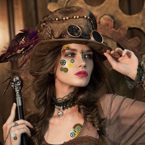 Frau im Steampunk-Outfit mit einem großen Hut, Zähnen und mechanischen Aufklebern im Gesicht, posiert mit einem Stock vor einem Zahnrad-Hintergrund.