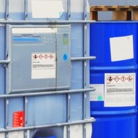 Hazardous Material and Dangerous Goods Labels: Hazardous material labels on chemical containers in outdoor areas.