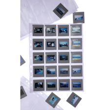 Eine Sammlung von Dias in einer durchsichtigen Hülle, mit mehreren Dias, die um die Hülle herum angeordnet sind.